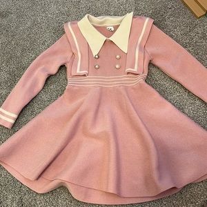 Cute pink and white sweater dress with half pearl buttons sewn on front. Size 4t